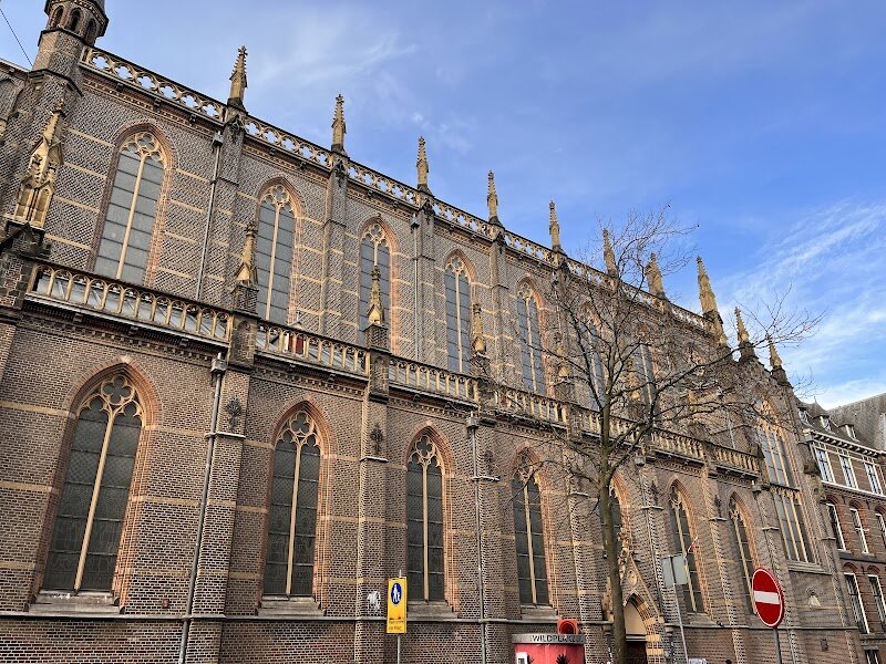 Dominicuskerk - Dominicuskerk, nestled on Spuistraat in the heart of Amsterdam, is a striking testament to the city’s layered history and creative spirit. Designed by renowned architect Pierre Cuypers—famous for the Rijksmuseum and Central Station—the church was completed in 1893 in the vibrant neo-Gothic style, with soaring arches, intricate stonework, and a beautifully painted wooden ceiling that captures the imagination of visitors of all ages. What makes Dominicuskerk truly unique is its transformation over time. Originally built for the Dominican Order, the church has evolved from a hidden Catholic mission in the 17th century into a lively, independent community known today for its inclusive and welcoming atmosphere. Families and curious travelers alike will be enchanted by the colorful murals, the warmth of the natural light streaming through stained glass, and the creative use of space—where the historic altar rail has been repurposed as a stage for music and storytelling. Visitors can experience uplifting services, inspiring concerts, and a sense of living history, all within a space that honors tradition while embracing change. Dominicuskerk invites everyone—regardless of background—to discover a place where heritage, art, and community come together in the heart of Amsterdam.