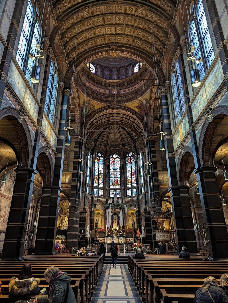 Basilica of Saint Nicholas - Step into the heart of Amsterdam and discover the **Basilica of Saint Nicholas**, a dazzling blend of history, artistry, and spiritual heritage that invites families and curious travelers alike. Completed in 1887, this iconic church stands as a symbol of religious freedom, built after centuries when Catholics could only worship in secret. Its striking façade—designed by Adrianus Bleijs—showcases neo-Baroque and neo-Renaissance elements, topped with two towers and a rose window depicting Christ and the four evangelists. Inside, visitors are greeted by soaring vaulted ceilings, vibrant stained glass windows, and intricate murals that tell stories from the life of Saint Nicholas, Amsterdam’s patron saint of seafarers—a nod to the city’s maritime roots. The high altar, adorned with copper and stone, is surrounded by angelic sculptures, while the church’s grand Sauer organ delights with its impressive sound during concerts and services. Whether you’re marveling at the artwork, enjoying a moment of quiet reflection, or joining a family-friendly scavenger hunt through its halls, the Basilica offers a peaceful retreat from the city’s bustle and a fascinating glimpse into Amsterdam’s rich past. It’s a must-visit destination where history, culture, and beauty come together, promising memorable experiences for visitors of all ages.