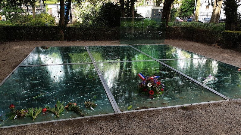 Memorial to Auschwitz Victims - The Memorial to Auschwitz Victims in Amsterdam, nestled in the peaceful Wertheimpark, is a deeply moving tribute that invites visitors of all ages to reflect on the tragic history of the Holocaust. Designed by renowned artist Jan Wolkers, its striking feature is six large sheets of broken mirror glass, laid flat to reflect the ever-changing sky—a powerful symbol of shattered lives and dreams. Beneath one glass panel lies an urn containing ashes from Auschwitz, while the words “Nooit Meer Auschwitz” (“Never Again Auschwitz”) stand as a solemn reminder of the promise to remember and never repeat such horrors. Families and curious travelers will find the memorial both educational and evocative. The serene atmosphere encourages quiet contemplation, and the artistic design bridges history and emotion, making it accessible even for younger visitors. Informative inscriptions in Dutch and English offer context and stories, helping everyone grasp the impact on Amsterdam’s Jewish community and the world. Surrounded by the greenery of the park and close to the city’s vibrant Jewish Quarter, the memorial is not only a place for remembrance, but also a springboard for learning and meaningful conversation—a must-see for anyone seeking understanding and connection in Amsterdam.