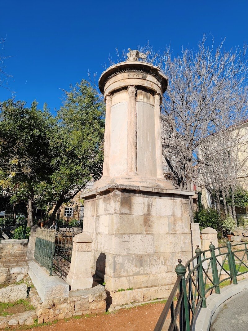 Choragic Monument of Lysicrates - The **Choragic Monument of Lysicrates** stands as a captivating window into Athens’ golden age, inviting families and curious travelers to experience the city’s rich artistic heritage firsthand. Erected in 334 BC to celebrate Lysicrates’ sponsorship of a victorious chorus in the dramatic festivals, this elegant marble structure is the only surviving example of a choragic monument—a tribute to Athens’ love for theater and the arts. Its design was groundbreaking, marking the first time the ornate **Corinthian order** appeared on the exterior of a Greek monument, a style that would inspire centuries of architecture. Nestled in the lively Plaka district, the monument is surrounded by charming streets, making it an ideal stop for families exploring Athens’ historical treasures. Visitors can marvel at the intricate friezes depicting mythical adventures, including Dionysus turning pirates into dolphins—a story sure to spark children’s imaginations. As you admire the artistry carved into the ancient stone, you’ll connect with the vibrant spirit of old Athens, where drama and democracy flourished. The Choragic Monument of Lysicrates offers a memorable experience—perfect for anyone eager to glimpse the creativity and communal pride that shaped one of history’s greatest cities.