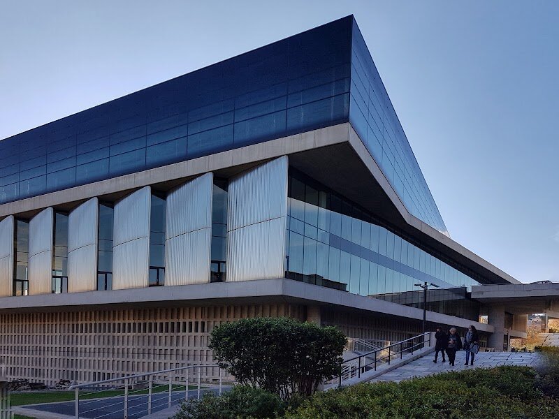 Acropolis Museum - Perched at the foot of the legendary Acropolis, the Acropolis Museum in Athens is a breathtaking gateway to ancient Greece, where history, art, and innovation come alive under one roof. Opened in 2009, this architectural masterpiece was designed by Bernard Tschumi to echo the grandeur of the Parthenon itself—its glass walls and open spaces offer mesmerizing views of the Acropolis, seamlessly connecting past and present. Inside, families and curious travelers can wander through galleries filled with treasures spanning millennia, from the Bronze Age to Roman and Byzantine times, all discovered on the slopes and summit of the Acropolis. The museum’s crowning jewel is the Parthenon Gallery, where the layout mirrors the temple’s dimensions, allowing you to walk among the original marble sculptures and friezes, including the famous Caryatids and the delicate relief of *Nike Adjusting Her Sandal*. As you explore, you’ll uncover the story of Athens’ Golden Age—when democracy, philosophy, and the arts flourished, and the Acropolis became a symbol of human achievement. Engaging multimedia displays and child-friendly exhibits make history accessible and exciting for all ages. Whether you’re marveling at the craftsmanship of ancient sculptors or gazing up at the illuminated Parthenon through the glass ceiling, the Acropolis Museum is a vivid, unforgettable journey into the heart of Western civilization.