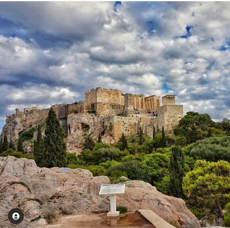 Areopagus Hill - Areopagus Hill, perched just northwest of the Acropolis, invites families and curious travelers to step into the heart of Athens’ ancient stories and legends. Known as the Hill of Ares, this striking marble outcrop is more than a scenic viewpoint—it’s a crossroads of mythology, philosophy, and world-changing events. According to legend, the gods themselves once held court here, trying Ares for murder, and later, the hill became the powerful seat of Athens’ high court, where serious crimes and civic matters were debated by the city’s wisest elders. The Areopagus is also a landmark for Christian history: it was here that the Apostle Paul delivered his famous sermon about the “unknown god,” sparking the spread of Christianity in Athens and beyond. As you climb the ancient, weathered steps, you’ll find yourself surrounded by breathtaking views of the Acropolis, the Parthenon, and the vibrant city below—a perfect spot for both reflection and family photos. Children can imagine legendary trials and ancient philosophers debating big ideas, while adults absorb the unique blend of myth, history, and panoramic beauty. Areopagus Hill is a living chapter of Athens, where every visitor can experience the city’s rich past and awe-inspiring vistas.