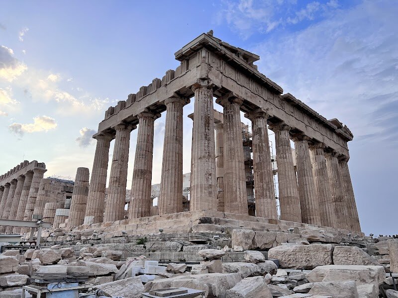 Parthenon - Perched atop the iconic Acropolis, the Parthenon is not just an ancient temple—it’s a living storybook of Athens, democracy, and the enduring spirit of the ancient Greeks. Built between 447 and 432 BCE, this masterpiece of Doric architecture was dedicated to Athena, the city’s protector, and originally housed a breathtaking gold-and-ivory statue of the goddess. Its flawless proportions and dazzling white marble have inspired architects and artists for centuries, making it a symbol of Western civilization. But the Parthenon’s magic goes beyond its columns and carvings. Its very stones whisper tales of triumph and tragedy: built to celebrate Athens’ victory over the Persians, it stands on the ruins of an earlier temple destroyed during the same wars. The sculptures adorning its walls—mythical battles between Greeks and centaurs—subtly retell the city’s struggles and resilience, inviting visitors to connect with the past in a deeply human way. Today, wandering around the Parthenon, families and curious travelers can marvel at the ingenuity of ancient builders, imagine the vibrant ceremonies that once took place here, and soak in panoramic views of modern Athens stretching below. It’s a place where history feels alive, where every visitor—young or old—can touch the legacy of a civilization that shaped the world. Whether you’re a history buff, an art lover, or simply seeking wonder, the Parthenon offers an unforgettable journey into the heart of ancient Greece.