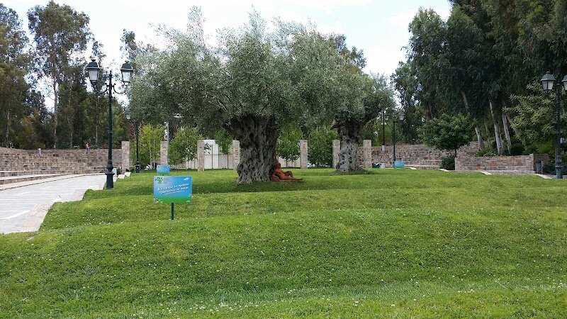Peristeri Park - Peristeri Park, known locally as **Alsos Peristeriou**, is a lush urban oasis that beckons families and curious travelers to discover a different side of Athens. Opened in 2012, this vibrant park quickly became a beloved retreat for locals, offering cool respite during the city’s hot summers—its abundant greenery and water features help lower temperatures by up to 5°C, according to studies by the University of Athens. What sets Peristeri Park apart is its blend of nature, culture, and playful energy. Children can explore a historically themed playground, enjoy puppet shows in summer, and let their imaginations run wild among acacia, fig, olive, and eucalyptus trees. Adults might appreciate the outdoor gym, summer concerts in the amphitheatre, or a stroll through the park’s Prasino Spiti (Green House), which spotlights green energy and sustainability initiatives. Rooted in history, Peristeri is believed to be the site of the ancient deme Leuconoe, adding a layer of intrigue to your visit. The name “Peristeri,” meaning “dove,” reflects the park’s peaceful spirit—a true haven where Athens’ urban pulse meets the tranquil beauty of nature and community. Whether you’re seeking relaxation, recreation, or a touch of local heritage, Peristeri Park offers a memorable experience for all ages.