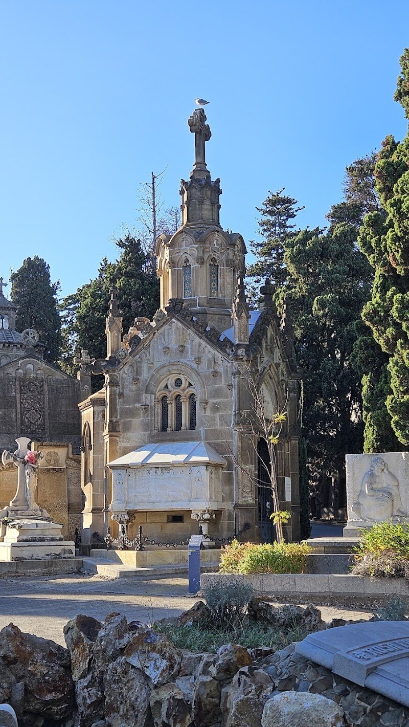 Cementiri de Montjuïc - Cementiri de Montjuïc is Barcelona’s largest and most evocative cemetery, perched dramatically on the slopes of Montjuïc Hill with sweeping views over the harbor and city below. Opened in 1883 during Barcelona’s rapid expansion, this cemetery became a showcase of Modernisme—the region’s unique take on Art Nouveau—making it a living museum of funerary art. Families and curious travelers alike will find themselves wandering through a labyrinth of winding paths lined with cypresses, ornate tombs, and monumental sculptures, each telling stories of the city’s past. What makes Cementiri de Montjuïc truly special is its role as the final resting place for a fascinating cross-section of Barcelona’s history: from renowned artists like Joan Miró to influential politicians and industrialists who shaped the city’s character. The cemetery’s terraced layout, reminiscent of an English garden, invites visitors to explore its tranquil corners, admire intricate stonework, and discover the only collection of historic hearses in Europe. A visit here is both moving and inspiring—a chance to reflect, learn, and experience Barcelona’s rich heritage in a peaceful, unexpected setting.