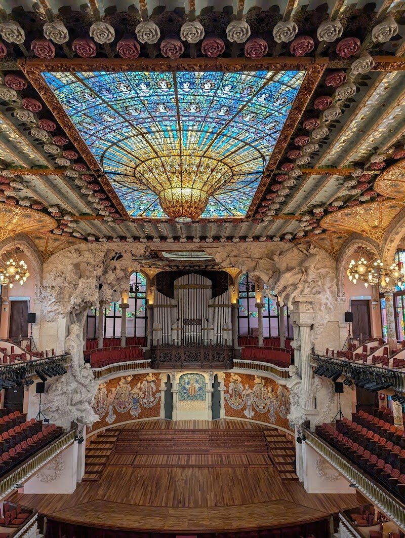 Palau de la Música Catalana - Step inside the **Palau de la Música Catalana** and discover a dazzling world where music and art blend in spectacular harmony. This **UNESCO World Heritage Site** is a masterpiece of Catalan Modernisme, designed by visionary architect **Lluís Domènech i Montaner** between 1905 and 1908. Built for the Orfeó Català choral society, the Palau stands as a vibrant symbol of the city's cultural renaissance and creative spirit. Families and curious travelers will be enchanted by the building’s whimsical beauty—mosaic pillars adorned with flowers, stained glass that bathes the concert hall in colorful light, and sculptures celebrating musical legends and Catalan folklore. Children and adults alike can marvel at the concert hall’s soaring glass dome, often described as a “musical garden” where every corner bursts with color and detail. Beyond admiring its architectural wonders, visitors can experience world-class performances ranging from classical concerts to local Catalan music, all in a magical setting designed to inspire awe and delight. The Palau de la Música Catalana invites you to witness the heartbeat of Barcelona’s artistic heritage—a place where every visit is a celebration for the senses.