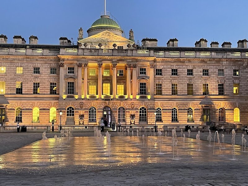 Somerset House - Somerset House is a stunning neoclassical landmark on the banks of the Thames, inviting families and curious travelers to step into centuries of London’s rich history. Once the grand vision of Edward Seymour, Duke of Somerset, the site began as a Renaissance palace for royalty and evolved into the elegant 18th-century masterpiece seen today. Its magnificent courtyard, framed by monumental wings and adorned with fifty-five playful fountain jets, is a hub of creativity and family fun—perfect for children to dash among the water in summer or for everyone to enjoy the festive ice rink in winter. Beyond its architectural grandeur, Somerset House pulses with cultural life. Visitors can explore world-class art exhibitions, hands-on workshops, and vibrant festivals set against a backdrop of soaring columns, nautical sculptures, and historic facades. The building’s storied past—once home to queens and the scene of lavish royal gatherings—adds a sense of discovery to every visit. Whether you’re exploring its interactive installations or simply soaking in the riverside views, Somerset House offers an inspiring blend of history, creativity, and family-friendly excitement in the heart of London.