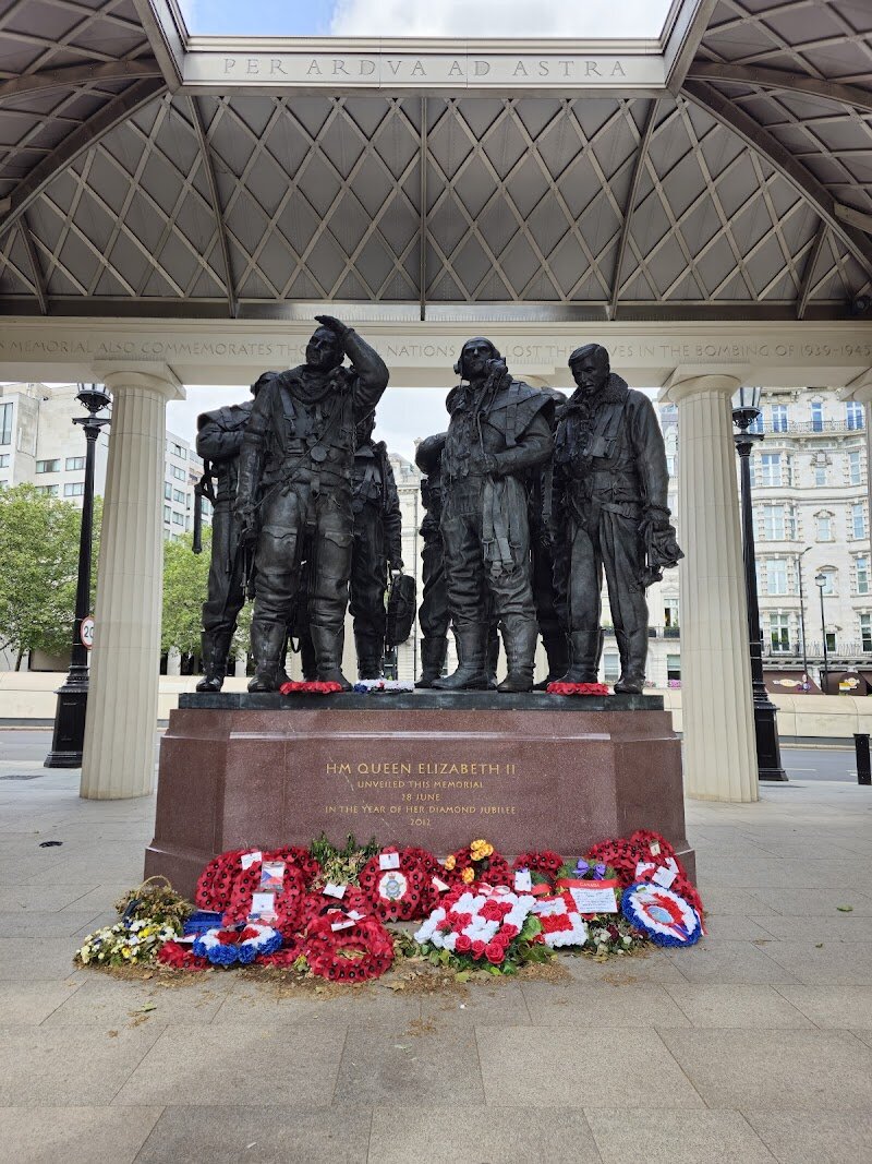Bomber Command Memorial - The **Bomber Command Memorial** in London’s Green Park is a moving tribute that brings history to life for visitors of all ages. Unveiled by Her Majesty The Queen in 2012, this powerful monument honors the 55,573 aircrew from the United Kingdom, Commonwealth, and other Allied nations who lost their lives serving in RAF Bomber Command during World War II. What makes this memorial truly special is its striking design: at its heart stand seven bronze statues, representing a bomber crew frozen in a moment of reflection and courage. Above them, the open roof lets daylight stream in, symbolizing the endless sky these young men once flew through. Look up and you’ll see the roof incorporates aluminum from an actual WWII Halifax bomber, connecting the monument to real stories of bravery and sacrifice. For families and curious travelers, the memorial offers a chance to pause and reflect on the extraordinary challenges faced by ordinary people, and to share in a story that shaped the world. Whether you’re drawn by the poignant sculptures, the evocative atmosphere, or the rich historical context, a visit here is both an educational journey and a heartfelt tribute to the past.