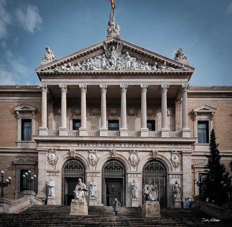 Biblioteca Nacional de España - Step into the Biblioteca Nacional de España and feel the weight of centuries of knowledge and culture. Founded in 1711 by King Philip V, this grand institution began as the Royal Library and has grown into Spain’s largest and most important library, a true treasure chest of the nation’s heritage. Located in the heart of Madrid, its majestic building on Paseo de Recoletos is a landmark of learning and history. What makes the Biblioteca Nacional so special? It’s not just a place for scholars—it’s a living museum of stories, ideas, and art. Here, you’ll find priceless treasures: ancient manuscripts, rare first editions, stunning maps, and even original works by literary giants like Cervantes. The library’s vast collection includes everything from medieval incunabula to modern digital archives, offering a journey through Spain’s rich past and vibrant present. Visitors can wander through elegant halls, admire historic architecture, and discover fascinating exhibitions that bring history to life. Whether you’re a curious traveler, a history lover, or exploring with family, the Biblioteca Nacional invites you to uncover the stories that shaped a nation. It’s a place where every book, every artifact, and every corner whispers tales of discovery and imagination.