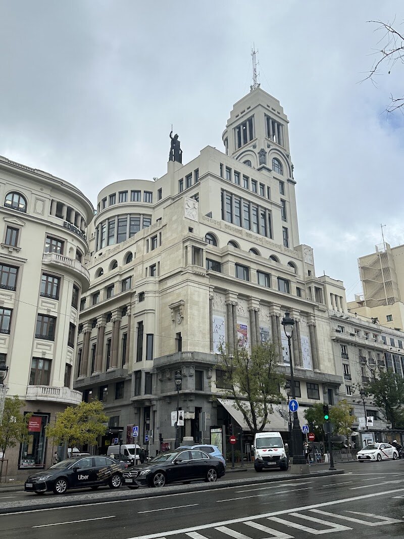 Círculo de Bellas Artes - Step into the Círculo de Bellas Artes, a true icon of Madrid’s cultural heartbeat, and you’ll feel the energy of over a century of art, ideas, and creativity. Founded in 1880 by a passionate group of artists and thinkers, this grand building on Calle de Alcalá is more than just a museum—it’s a living space where art, music, theater, and conversation thrive. Designed by the visionary architect Antonio Palacios, its striking façade blends historic elegance with modern flair, crowned by the majestic statue of Minerva, goddess of wisdom, watching over the city. Inside, every floor tells a story. Marvel at the dramatic staircase, ornate columns, and light-filled halls, then explore galleries, theaters, and exhibition spaces that host everything from contemporary art to classic cinema. The Círculo has been a meeting place for Spain’s greatest minds and artists, and today it welcomes families and curious travelers to join in its vibrant spirit. Whether you’re drawn by history, inspired by creativity, or simply want to soak up the atmosphere of a place where culture comes alive, the Círculo de Bellas Artes promises an unforgettable experience in the heart of Madrid.