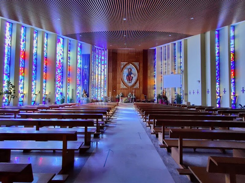 Parroquia de Santa Teresa Benedicta de la Cruz - # Discover the Castle Church of Madrid Nestled beside Plaza de España stands one of Madrid's most enchanting architectural mysteries—a church that looks remarkably like a medieval fortress. The Church of Santa Teresa y San José, also known as the National Temple of Santa Teresa de Jesús, captivates visitors with its striking blend of Gothic, Byzantine, and modernist styles that creates something truly unique in the Spanish capital. Built between 1916 and 1928 for the Discalced Carmelite order, this eclectic masterpiece was inspired by Santa Teresa's spiritual work "Las Moradas" (The Interior Castle), which explains its fortress-like appearance with crenellated walls and protective turrets. The real showstopper is the breathtaking 35-meter-high Byzantine dome adorned with vibrant polychrome tiles in yellows, oranges, reds, and blues—a design that has sparked curiosity among countless passersby wondering if Madrid secretly harbors a hidden mosque. Step inside to discover a serene interior flooded with light, featuring a magnificent 19-meter altarpiece with a 4.5-meter statue of Saint Teresa. The side chapels house stunning oil paintings, while intricate stained glass windows by Maumejean cast colorful patterns across the sacred space. This is more than a church; it's an architectural journey through centuries of artistic vision.