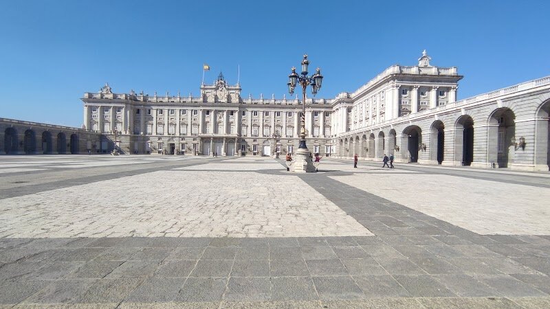 Royal Palace of Madrid - The Royal Palace of Madrid stands as one of Europe's most magnificent royal residences, a breathtaking testament to centuries of Spanish history and architectural grandeur. Built on the site of an ancient Moorish fortress, this 18th-century masterpiece rose from the ashes after the original Alcázar burned down in 1734, with construction spanning from 1738 to 1764. This architectural marvel seamlessly blends Baroque, Rococo, and Neoclassical styles, creating an enchanting fusion that captivates visitors. With over 3,000 opulently decorated rooms, the palace showcases the pinnacle of royal luxury—from the dazzling Throne Room adorned with golden mouldings and Tiepolo's painted ceiling to the elegant Main Staircase featuring more than 70 steps. The palace's white limestone and granite façade exudes timeless elegance, while the striking Courtyard of the Princes creates an unforgettable first impression. Beyond its stunning interiors, visitors can explore the Royal Armoury's impressive historical weapons collection and the Royal Chapel housing rare Stradivari string instruments. Whether you're marveling at intricate sculptures, wandering through grand halls, or soaking in centuries of Spanish heritage, the Royal Palace offers an immersive journey into the splendor of monarchy and European cultural legacy.