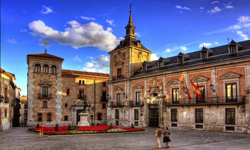 Casa de La Villa. City of Madrid - # Casa de la Villa: Madrid's Seat of Power Through the Centuries Nestled in the heart of Madrid's historic center, Casa de la Villa stands as a magnificent testament to centuries of civic governance and architectural elegance. This stunning Baroque masterpiece was commissioned by King Felipe IV in 1629 and completed in 1692, serving as Madrid's city hall until 2007. What makes Casa de la Villa truly special is its role as the beating administrative heart of Madrid. For over three centuries, mayors debated, nobles forged alliances, and important decisions that shaped the city were made within these walls. The building itself captivates visitors with its restrained Habsburg Baroque façade, distinctive slate spires, and an elegant gallery of columns added in the late 18th century. Step inside and discover richly decorated rooms adorned with ornate ceilings featuring frescoes by Antonio Palomino, 17th-century tapestries, and portraits reflecting Madrid's civic heritage. Today, Casa de la Villa hosts ceremonial events and welcomes curious travelers who want to experience Madrid's aristocratic past. Standing before this architectural gem, you can almost hear the echoes of formal processions and decisions that transformed Madrid into Spain's capital.