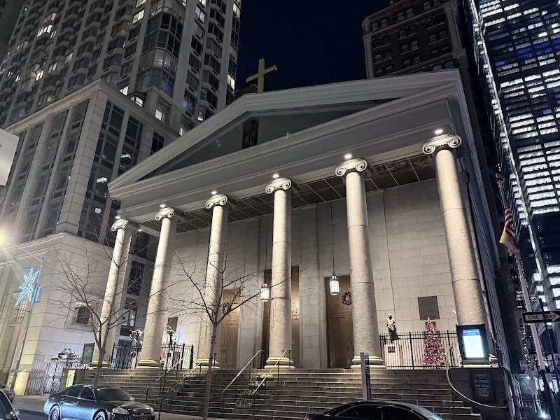 St Peter's Roman Catholic Church - St. Peter’s Roman Catholic Church in Lower Manhattan is a hidden gem with a story as rich as New York itself. Founded in 1785, it is the **oldest Catholic parish in New York State**, predating even the first U.S. bishopric. Its current Greek Revival structure—marked by stately Ionic columns and a dignified granite façade—was completed in 1840, offering a striking contrast to the city’s modern skyscrapers. Step inside and you’ll discover a sanctuary filled with history and artistry. Families and travelers can admire the radiant stained-glass windows, each depicting scenes from the life of Christ in vivid Renaissance colors. Above the main altar hangs a remarkable 18th-century Crucifixion painting, gifted from Mexico—a testament to the church’s global connections and enduring legacy. The original wooden pews, crafted from local trees in the 1840s, invite visitors to imagine the generations who have worshiped here. St. Peter’s is more than a church—it’s a living piece of New York’s story, having survived the events of September 11, 2001, just a block away. Whether you come for quiet reflection, awe-inspiring art, or a sense of history, St. Peter’s offers a welcoming space where the city’s past and present meet.