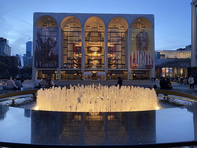 Lincoln Center for the Performing Arts - Lincoln Center for the Performing Arts is a vibrant cultural oasis in the heart of Manhattan, where families and curious travelers can immerse themselves in the world’s finest music, dance, theater, and film. Spanning over 16 acres, this iconic complex was brought to life in the 1960s through the vision of philanthropist John D. Rockefeller III, who led a movement to create a unified home for New York’s leading arts organizations during a sweeping urban renewal project. What makes Lincoln Center truly special is its dazzling variety: from the soaring Metropolitan Opera House and the home of the New York Philharmonic, to the lively David H. Koch Theater and the intimate Alice Tully Hall, each venue offers unique experiences under one architectural masterpiece. Visitors can marvel at the grand travertine facades, gather by the central fountain, and enjoy everything from world-class opera and ballet to free outdoor concerts and multicultural festivals that welcome all ages. Whether you’re attending a family-friendly matinee, exploring the public plazas, or simply soaking in the artistic atmosphere, Lincoln Center invites you to discover the magic of the performing arts at the very heart of New York City.