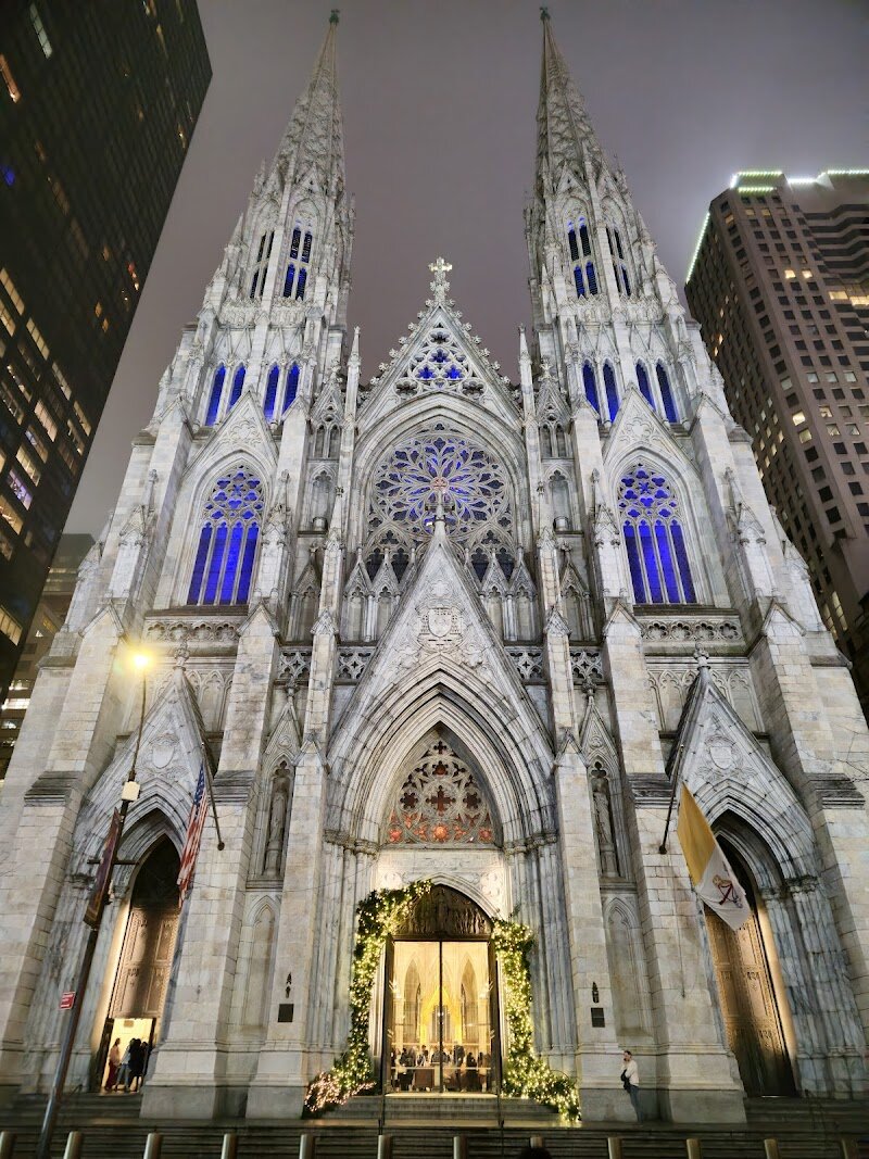 St. Patrick's Cathedral - St. Patrick’s Cathedral stands as a breathtaking icon in the heart of Manhattan, captivating families and travelers with its soaring spires, luminous stained-glass windows, and intricate Gothic Revival architecture. Designed by James Renwick Jr., this magnificent cathedral was constructed between 1858 and 1879, overcoming delays from the Civil War and relying on the dedication of New York’s growing Catholic community—many of them Irish immigrants. Stepping inside, visitors are greeted by a vast, white marble sanctuary that can seat over 2,000 people, with dazzling artistry at every turn: the famous rose window, altars designed by Tiffany & Co., and a monumental pieta sculpture three times the size of Michelangelo’s original. Beyond its architectural splendor, St. Patrick’s is a living landmark where history and daily life intertwine. It has hosted grand ceremonies, weddings, and even appeared in classic films. Families can marvel at the towering columns and colorful light streaming through stained glass, while curious travelers will appreciate the cathedral’s role as both a spiritual haven and a testament to New York’s immigrant spirit. Whether you’re seeking inspiration, art, or a glimpse into the city’s vibrant heritage, St. Patrick’s Cathedral offers an unforgettable experience for all ages.