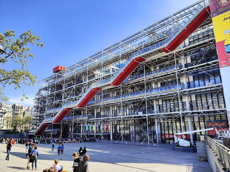 The Centre Pompidou - The Centre Pompidou is one of Paris’s most imaginative landmarks, instantly recognizable by its bold “inside-out” architecture—where brightly colored pipes and transparent escalators snake along the exterior, creating a playful, futuristic vibe in the heart of the city. Conceived in the late 1960s by President Georges Pompidou and opened in 1977, this cultural hub was designed by Renzo Piano and Richard Rogers to make art and creativity accessible to everyone, welcoming families and curious minds of all ages. Step inside and you’ll discover a treasure trove of modern and contemporary art, a vibrant public library, hands-on workshops, and a rooftop terrace offering sweeping views of Paris. Kids will love the interactive exhibits and the lively piazza out front, where street performers and pop-up events add to the festive atmosphere. With its flexible, open spaces and ever-changing exhibitions, the Centre Pompidou is a place where art, music, and imagination come alive—a must-see for travelers eager to explore the cutting edge of culture and creativity in a city renowned for its tradition.