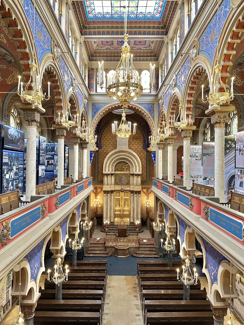 Jerusalem Synagogue - The **Jerusalem Synagogue** in Prague is a dazzling hidden gem that promises to captivate families and curious travelers alike. Step onto Jerusalem Street and you’ll be greeted by a vibrant facade—striped in red and white, adorned with Moorish arches and crowned by a striking rosette window—that stands out as one of the city’s most colorful landmarks. Built in 1906, this synagogue blends **Moorish Revival** and **Art Nouveau** styles, making it a feast for the eyes both inside and out. Inside, you’ll discover a riot of color: intricate geometric patterns, brilliant blues, pinks, and golds, and ornate flourishes that create an atmosphere of wonder. The synagogue was designed by Viennese architect Wilhelm Stiassny as a replacement for three historic synagogues lost during the modernization of Prague’s Jewish Quarter, giving it deep historical significance. Today, the Jerusalem Synagogue is not just a place of worship—it’s a vibrant cultural hub. Visitors can explore exhibitions on Prague’s Jewish history, admire a beautifully preserved organ, and even attend summer concerts. Whether you’re exploring with children or seeking architectural marvels, this synagogue offers a welcoming window into Prague’s rich Jewish heritage and artistic spirit.