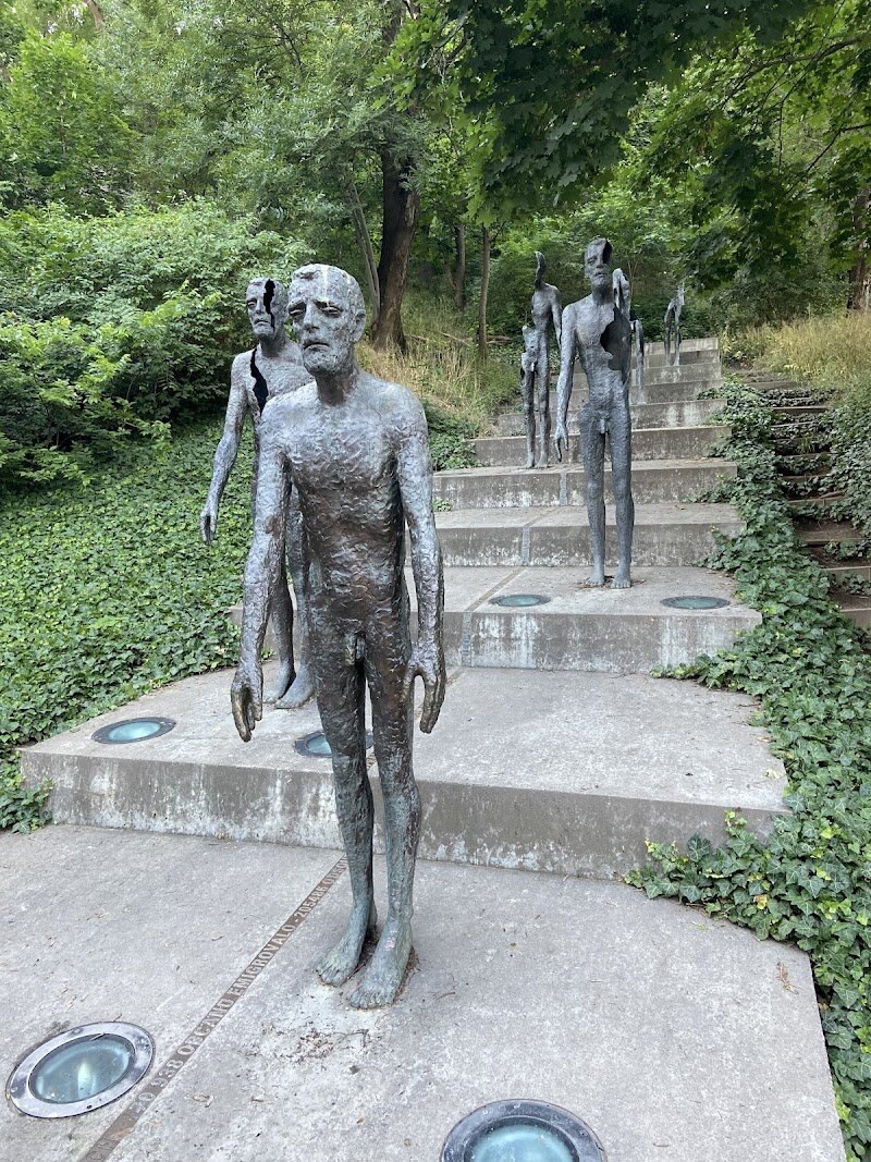 Memorial to the Victims of Communism - The **Memorial to the Victims of Communism** in Prague is an unforgettable monument that invites visitors of all ages to reflect on the city’s turbulent 20th-century history. Located at the foot of Petřín Hill, this striking memorial features seven bronze figures ascending a staircase, each appearing increasingly fragmented and worn. This powerful artistic design—by Olbram Zoubek, Jan Kment, and Zdeněk Hozman—symbolizes the devastating physical and psychological toll of communist rule on ordinary people. Families and curious travelers will find the memorial both thought-provoking and accessible. Children can count the statues and notice how each figure changes, sparking conversations about resilience and hope. The monument’s bronze plaque spells out the staggering human cost: thousands imprisoned, executed, or forced to flee during the regime from 1948 to 1989. The experience is heightened by the quiet park setting, where candles and wreaths often mark remembrance. A visit here offers more than solemn reflection—it’s a chance to connect with Prague’s living history, appreciate the courage of those who endured hardship, and understand the importance of freedom. The haunting sculptures and evocative setting make this memorial a must-see for anyone seeking meaning and inspiration in Prague.
