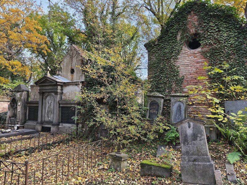 Olšany Cemetery - Olšany Cemetery, Prague’s largest and most storied burial ground, invites visitors to step into three centuries of history and quiet beauty. Founded in 1680 in response to a devastating plague, Olšany has grown into a sprawling complex of twelve distinct cemeteries, each reflecting Prague’s rich tapestry of cultures and faiths—from Catholic and Orthodox to Jewish and Muslim communities. Families and curious travelers will be captivated by the cemetery’s serene paths lined with magnificent Art Nouveau monuments, centuries-old tombstones, and ornate chapel graves. It’s a peaceful haven for reflection, where the city’s past comes alive through stories etched in stone. Notable Czechs rest here, including artist Alphonse Mucha and student Jan Palach, whose grave tells of heroic protest for freedom. Literature lovers can seek out Franz Kafka in the Jewish section. Olšany’s tranquil atmosphere is perfect for a quiet walk or a moment of discovery. As you wander, you’ll encounter military memorials, local legends (including Prague’s only enduring vampire myth!), and a unique blend of art, history, and nature. Whether you’re exploring with family or on a personal quest for Prague’s secrets, Olšany Cemetery offers a memorable, moving experience for all ages.
