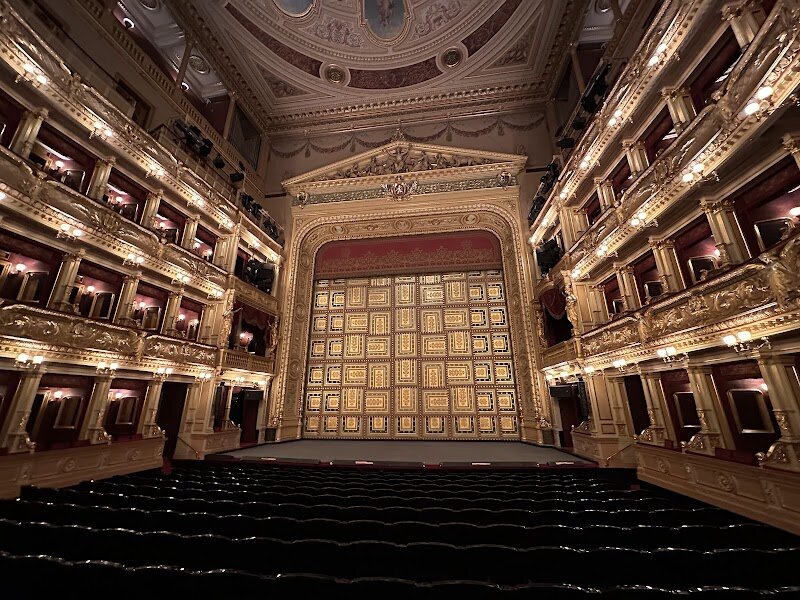 National Theatre - The **National Theatre in Prague** stands as a dazzling symbol of Czech pride and creativity, inviting families and curious travelers to step into a world where history and artistry intertwine. Rising majestically along the Vltava River, this Neo-Renaissance masterpiece was born from a wave of patriotic enthusiasm in the 19th century—funded entirely by the Czech people and designed by architect Josef Zítek. Its dramatic story includes a devastating fire shortly after its 1881 opening, followed by a passionate national campaign to rebuild, making each performance here a tribute to resilience and unity. Inside, visitors are greeted by opulent interiors adorned with allegorical sculptures and vibrant murals inspired by Czech legends. Beyond the main stage, the complex includes the striking modern New Stage, once home to the world’s first multimedia theatre, Laterna Magika, blending tradition with innovation. Families will delight in the theatre’s lively program of ballets, operas, and plays—each offering a window into Czech culture. Whether marveling at the golden-topped façade or exploring its diverse performances, the National Theatre promises an unforgettable journey through the heart of Prague’s artistic spirit.