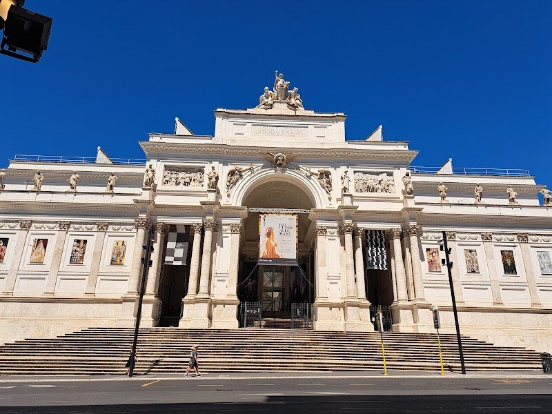 Palazzo delle Esposizioni - Located in the heart of Rome, the Palazzo delle Esposizioni is a vibrant cultural hub that has been enchanting visitors for over 140 years. This majestic white palace was designed by renowned architect Pio Piacentini and inaugurated in 1883, marking a significant milestone in Rome's cultural landscape. The building's unique design, inspired by classicist traditions with an international flair, features a striking facade with no windows, allowing natural light to filter in through its iron and glass roofs. This multidisciplinary space offers an array of experiences, from art exhibitions to concerts and educational activities. Families and curious travelers alike can explore over 3,000 square meters of exhibition space, a cinema hall, and an auditorium. The Palazzo is a place where history meets innovation, providing a rich program of events that engage with the city's past while embracing modernity. Whether you're an art enthusiast or simply looking for a unique experience, the Palazzo delle Esposizioni is a must-visit destination in Rome.