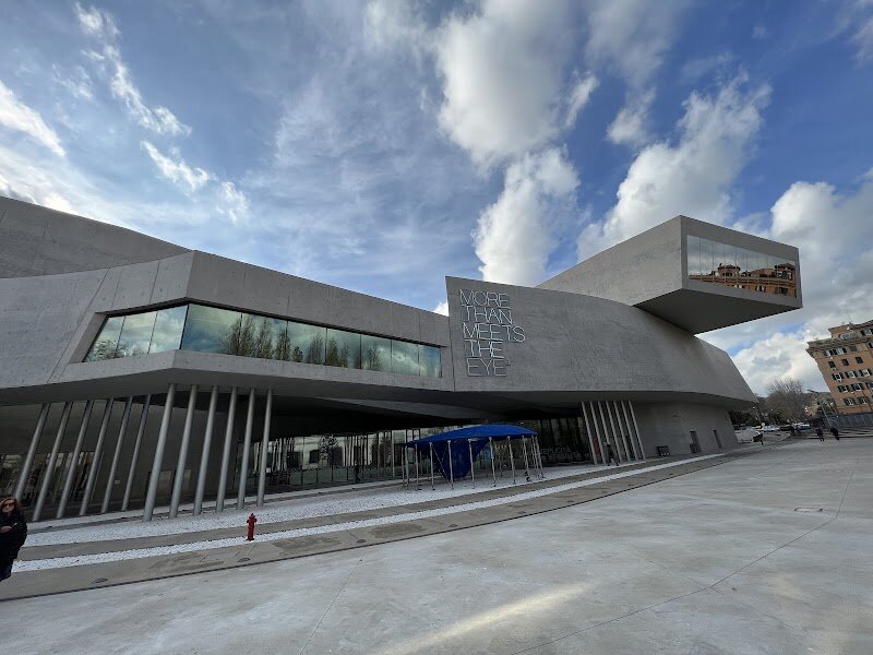 MAXXI - National Museum of 21st Century Art - MAXXI – the National Museum of 21st Century Art in Rome – is a thrilling destination for families and inquisitive travelers eager to explore the cutting edge of creativity. Designed by renowned architect **Zaha Hadid**, MAXXI is itself a masterpiece: a flowing, futuristic building of sweeping curves, bold concrete forms, and sunlit galleries that invite you to wander and discover at every turn. Opened in 2010 on the site of a former army barracks, MAXXI is Italy’s first national museum dedicated to contemporary art and architecture, symbolizing Rome’s embrace of the present and future while remaining rooted in its rich past. Inside, visitors are treated to a dynamic blend of **ever-changing exhibitions**, interactive installations, and hands-on activities that spark curiosity in all ages. Children and adults alike can marvel at vibrant art, imaginative design, and photography collections that showcase the ideas shaping our world today. The museum’s innovative spaces, including an airy atrium, creative workshops, and a lively bookshop, make every visit an adventure. At MAXXI, you’re not just viewing art—you’re immersed in a living, evolving world of inspiration.