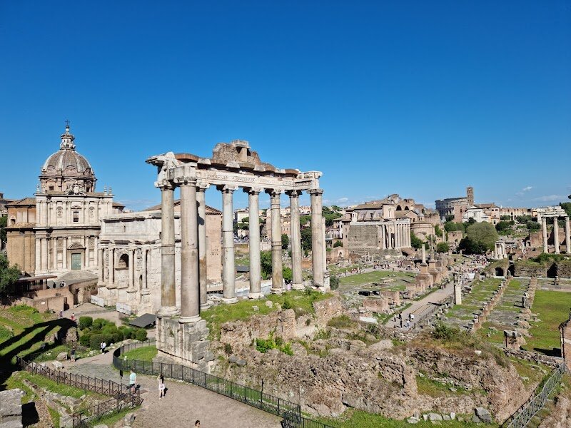 Roman Forum - The **Roman Forum** is an unforgettable destination where families and curious travelers can step into the very heart of ancient Rome’s history. Once a bustling center of political, social, and religious life, this grand plaza was where senators debated, emperors celebrated victories, and everyday Romans gathered for festivals and markets. Today, wandering its ancient paths, visitors encounter the awe-inspiring remains of temples, basilicas, and triumphal arches—each structure echoing dramatic stories from over two thousand years ago. What makes the Roman Forum special is its unique ability to transport you back in time. Imagine standing where Julius Caesar walked, seeing the majestic columns of the Temple of Saturn, or picturing the Senate’s heated discussions in the Curia. The Forum’s ruins come alive for all ages, sparking curiosity and wonder as you explore monumental sites like the Arch of Septimius Severus and the Basilica of Maxentius. From the nearby hills, the sweeping views reveal the sheer scale and grandeur of ancient Rome’s “living room.” Whether you’re a family seeking adventure or a traveler fascinated by history, the Roman Forum offers a hands-on journey through the epicenter of Rome’s glorious past—a place where every corner has a story to tell.