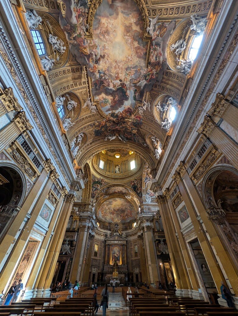 Chiesa del Gesù - Chiesa del Gesù, nestled in the heart of Rome, is a breathtaking fusion of history, art, and spiritual grandeur that captivates visitors of all ages. Stepping inside, families and curious travelers are greeted by soaring Baroque architecture, gilded marble, and a dazzling ceiling fresco—Gaulli’s “Triumph of the Name of Jesus”—that seems to spill heavenly light into the nave. This church isn’t just beautiful; it’s the **mother church of the Jesuit order**, serving as a blueprint for countless churches around the world and marking a turning point in religious architecture. Founded in 1551 by Saint Ignatius of Loyola and completed in the late 16th century, Chiesa del Gesù was designed to draw people together, focusing attention on the high altar and the stirring sermons that once echoed through its acoustically masterful single nave. Children and adults alike will marvel at the illusionistic art, including Andrea Pozzo’s ingenious painted architecture behind the altar, and explore chapels filled with centuries-old treasures. Whether you’re tracing the footsteps of history or simply soaking in the spectacle, Chiesa del Gesù offers a memorable encounter with Rome’s artistic and spiritual legacy—a place where the past comes alive in every golden detail.