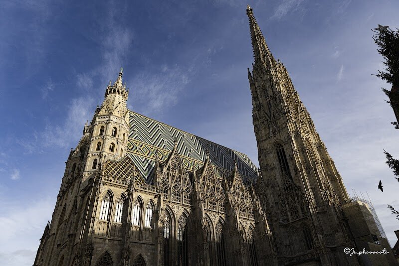 St. Stephen's Cathedral - St. Stephen's Cathedral stands as Vienna's most iconic landmark, a breathtaking Gothic masterpiece that has watched over the city for nearly nine centuries. Originally consecrated as a modest Romanesque parish church in 1147, this architectural gem underwent a dramatic transformation beginning in the 14th century, evolving into the stunning cathedral visitors admire today. What truly captures the imagination is the cathedral's distinctive silhouette, dominated by the soaring South Tower—affectionately called "Steffl" by locals—which rises 136 meters into the Vienna skyline. The tower took 65 years to complete, finally finished in 1433 after becoming Europe's tallest church tower for nearly 50 years. But the real showstopper is the ornately patterned roof, covered with 230,000 glazed tiles forming a magnificent double-headed eagle—a symbol of Habsburg imperial power. Inside, visitors encounter centuries of artistic devotion, including the stunning Baroque High Altar built between 1641 and 1647. Walking through the Giant's Doorway, you're stepping into living history, experiencing layers of architectural styles and witnessing a structure that survived devastating World War II damage to become a symbol of Austria's resilience. Every stone tells a story of faith, ambition, and cultural pride.