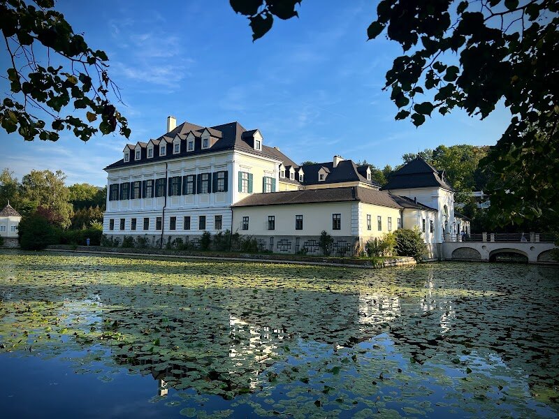 Laudon Palace - Step into a fairytale at Laudon Palace, a Baroque gem nestled in Vienna’s lush Penzing district. Originally a medieval moated castle dating back to the 12th century, it was transformed into a grand Baroque residence in the 18th century, blending centuries of history with elegant architecture. Surrounded by serene parklands and a tranquil moat, the palace offers a peaceful escape from the city, where families can wander through picturesque gardens and imagine life in imperial times. Laudon Palace is more than just a beautiful building—it’s a place where history comes alive. Marvel at the ornate frescoes inside, stroll along tree-lined paths, and discover the stories of the Habsburg Empire that shaped this enchanting estate. The palace’s idyllic lakeside setting and majestic halls make it a favorite for weddings and events, but it’s equally magical for curious travelers seeking a glimpse of Vienna’s imperial past. Whether you’re exploring the park, admiring the architecture, or simply soaking in the atmosphere, Laudon Palace promises a memorable experience for all ages.
