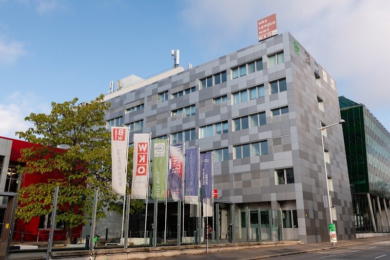 FHWien of WKW - FHWien der WKW stands as Austria's premier university of applied sciences for management and communication, nestled in Vienna's vibrant WKO campus on Währinger Gürtel. Founded in 1994 as a pioneer in Austria's university of applied sciences sector, this institution has evolved into a dynamic hub where theory meets real-world practice. What truly sets FHWien apart is its distinctive philosophy: "Study the practice." Two-thirds of its faculty are seasoned experts and managers directly from the business world, bringing authentic industry experience into classrooms. This creates an electrifying learning environment where students don't just absorb concepts—they engage with professionals actively shaping Vienna's business landscape. The campus itself reflects this commitment to excellence. Since consolidating at its current location in 2007, FHWien has expanded to over 9,000 square meters, housing not only academic departments but also WIFI Vienna and the prestigious Hernstein Institute for Management & Leadership. Over 15,900 graduates have emerged from these halls since its founding, each carrying practical knowledge into Vienna's thriving economy. For curious travelers, FHWien represents Vienna's modern intellectual pulse—where centuries-old Austrian business traditions blend seamlessly with contemporary management innovation and entrepreneurial spirit.