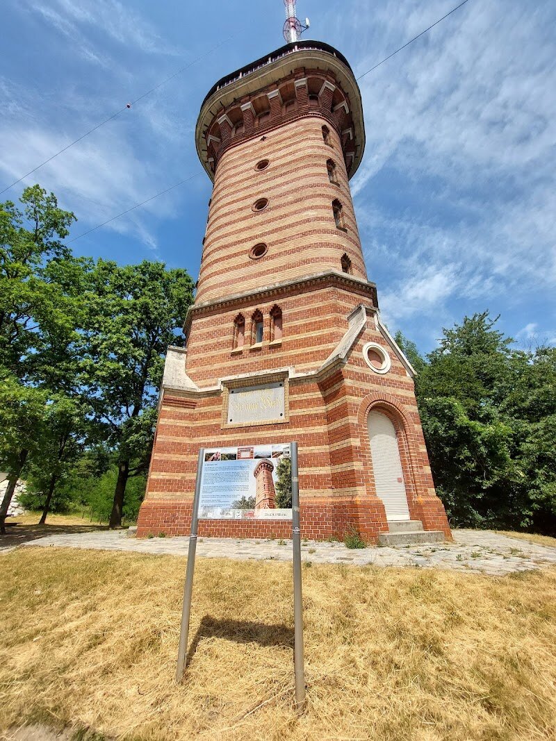 Kronprinzessin-Stefanie-Warte - Perched atop Vienna's beloved Kahlenberg hill, the **Kronprinzessin-Stefanie-Warte** stands as a 22-meter stone observation tower steeped in imperial history and architectural elegance. Built in 1887 by the renowned architectural firm Fellner & Helmer, this iconic landmark was named to honor Crown Princess Stephanie of Belgium, wife of Crown Prince Rudolf. What makes this tower truly special is its commanding vantage point offering **unparalleled panoramic views** of Vienna's most treasured sights. From the observation platform, you'll gaze upon St. Stephen's Cathedral, the Giant Ferris Wheel in the Prater, and on clear days, even the distant Alpine foothills. The tower itself carries fascinating stories—some of its bricks were recycled from an old cable car, connecting past to present. Beyond the tower, the Kahlenberg experience extends to charming cafés serving traditional Viennese cuisine, the baroque St. Joseph's Church, and the Forest Rope Park for adventurous families. Whether you're seeking a peaceful escape, a glimpse into Vienna's rich heritage, or simply breathtaking city views, the Stefaniewarte delivers an unforgettable journey through time and landscape.
