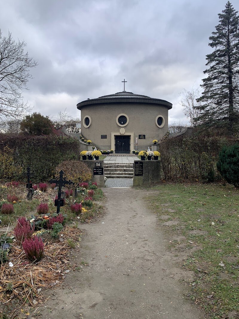Friedhof der Namenlosen, Vienna - # Friedhof der Namenlosen: Vienna's Most Unique Cemetery Nestled along the Danube River in Vienna's Simmeringen district lies a cemetery unlike any other in the world. The Friedhof der Namenlosen—the Cemetery of the Nameless—is the only burial ground globally dedicated exclusively to victims of a river. Between 1840 and 1940, this poignant memorial honored over 478 individuals who were swept ashore by the Danube, often unidentified and unclaimed. A powerful water vortex once deposited bodies at this exact location, prompting locals to create this dignified resting place for society's forgotten souls. Each grave is marked with an identical wrought-iron cross bearing a white Christ figure—a humble yet moving tribute. What makes this cemetery truly extraordinary is the dedication of Josef Fuchs, a volunteer caretaker who devoted 60 years to maintaining the grounds and identifying the deceased. Through meticulous research, he managed to identify all but one of the bodies he buried, transforming namelessness into remembrance. Today, this serene sanctuary—sheltered by towering trees and maintained by the Fuchs family across three generations—stands as a moving testament to compassion, dignity, and the human desire to honor even the most forgotten lives.